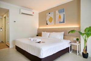 a bedroom with a large bed with white sheets at SWISS AVENUE HOTEL in Sungai Petani