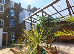 a courtyard with plants and a glass roof at Wellington View: Ground floor apartment with sea views and garden in Kent