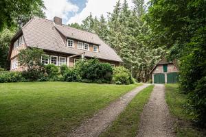 uma casa com uma estrada de terra em frente em Ferienwohnungen Zum Hülsenbusch em Bispingen