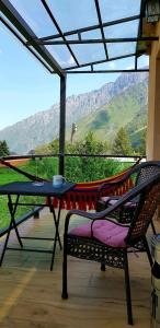 a table and a chair on a balcony with a view at North Kazbegi in Stepantsminda