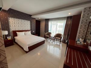 ein Hotelzimmer mit einem Bett, einem Tisch und Stühlen in der Unterkunft Nam Hy 1 Hotel in Ho-Chi-Minh-Stadt