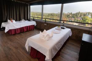 two tables in a room with a view at Bella Vista Mahabaleshwar in Mahabaleshwar