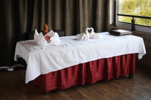 a bed with two swans sitting on top of it at Bella Vista Mahabaleshwar in Mahabaleshwar