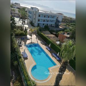 an overhead view of a swimming pool with chairs and a building at Hotel Costa Azul in Balestrate