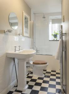 a bathroom with a sink and a toilet and a mirror at Romantic cottage, Old Town, Hebden Bridge in Heptonstall