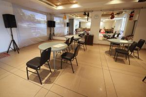 a conference room with tables and chairs and a screen at Bella Vista Mahabaleshwar in Mahabaleshwar