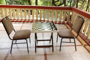 two chairs and a chess board on a balcony at Bella Vista Mahabaleshwar in Mahabaleshwar