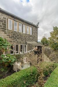 a brick house with a table in front of it at Romantic cottage, Old Town, Hebden Bridge in Heptonstall