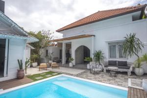 a villa with a swimming pool and a house at Gypsy Moon Bali in Canggu