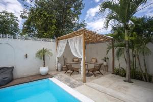 a patio with a pool and a table and chairs at Gypsy Moon Bali in Canggu