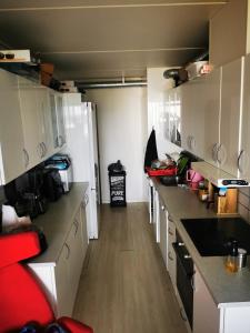 une cuisine avec des placards blancs et un grand comptoir dans l'établissement Midt Town Apartment Room, à Aarhus