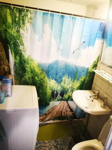 a bathroom with a mountain view shower curtain at Midt Town Apartment Room in Aarhus