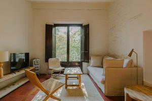a living room with a couch and a tv at Flateli Santa Clara 12 in Girona