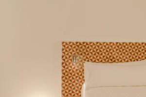 a bedroom with a bed with a brown and white headboard at Flateli Santa Clara 12 in Girona +4 photos