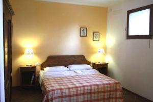 1 dormitorio con 1 cama con 2 lámparas en 2 mesas en Agriturismo La Torretta, en Siena