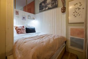 um pequeno quarto com uma cama num quarto em HONORÊ SUITE SAINT NIZIER em Lyon