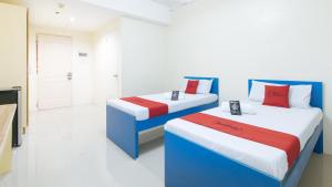 2 posti letto in una camera con rosso e blu di RedDoorz @ Insular Square Mandaue City a Mandaue