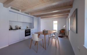 a kitchen with a wooden table and white chairs at Refugium 1744 in Oberscheinfeld