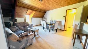 ein Wohnzimmer mit einem Sofa, einem Tisch und Stühlen in der Unterkunft Au Petit Vivoin in Vivoin