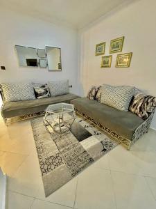 a living room with two couches and a rug at Superbe Appartement Avec Cheminée in Tangier