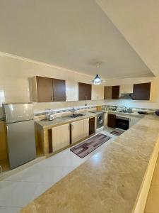 a large kitchen with wooden cabinets and stainless steel appliances at Superbe Appartement Avec Cheminée in Tangier