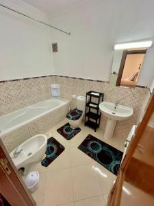 a bathroom with a tub and a toilet and a sink at Superbe Appartement Avec Cheminée in Tangier