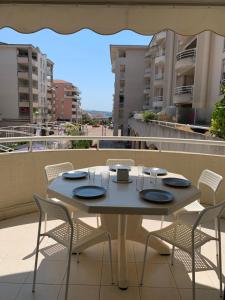 une table sur le toit d'un immeuble avec des chaises dans l'établissement 2P 42m² Terrasse / Piscine / Clim / Plage !, à Juan-les-Pins