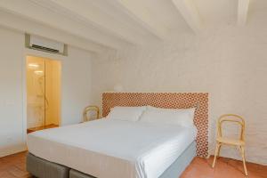 un dormitorio con una cama y una silla en Flateli Santa Clara 22, en Girona