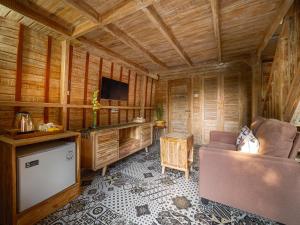 a living room with a couch and a tv in a cabin at Wisnu Lumbung Uluwatu in Uluwatu