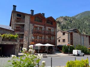 a large building with a table in front of it at Hotel Segle XX in El Tarter