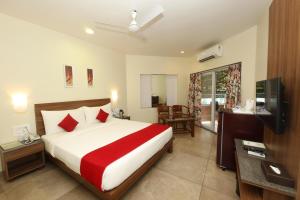 a hotel room with a bed and a television at Bella Vista Mahabaleshwar in Mahabaleshwar
