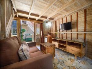 a living room with a couch and a flat screen tv at Wisnu Lumbung Uluwatu in Uluwatu