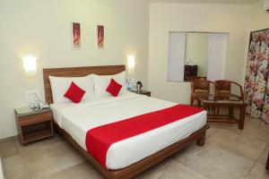 a bedroom with a large bed with a red blanket at Bella Vista Mahabaleshwar in Mahabaleshwar