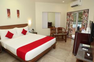 a bedroom with a large bed with a red blanket at Bella Vista Mahabaleshwar in Mahabaleshwar