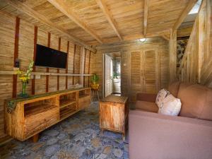 a living room with a couch and a flat screen tv at Wisnu Lumbung Uluwatu in Uluwatu