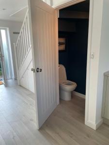 a bathroom with a toilet and a staircase at The Bolt Hole Hythe panoramic coast and sea views in Kent