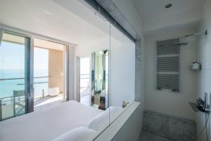 a white bathroom with a view of the ocean at Hotel Excelsior in Pesaro