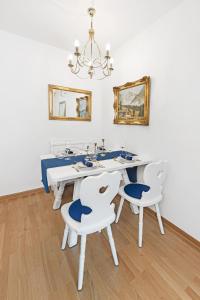 a dining room with a white table and chairs at Zwei Zimmer Wohnung im Stadtzentrum mit Tiefgaragenplatz in Munich