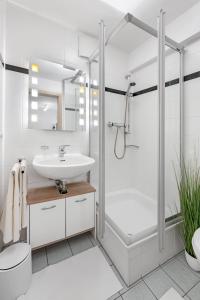 a white bathroom with a shower and a sink at Zwei Zimmer Wohnung im Stadtzentrum mit Tiefgaragenplatz in Munich
