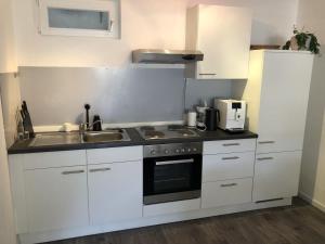 a white kitchen with a sink and a stove at Ferienwohnung Am Sonnenhang in Enzklösterle