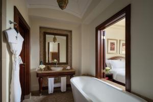 a bathroom with a tub and a sink and a mirror at Sofitel Bahrain Zallaq Thalassa Sea & Spa in Manama