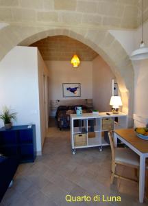 a living room with a table and a room with an arch at La Luna e il Gatto in Favignana