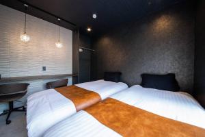 two beds sitting next to each other in a bedroom at THE BEEHIVE AIOI in Otaru