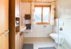 bagno con servizi igienici, lavandino e finestra di Haus Helga a Schoppernau