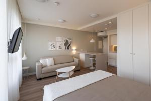 um quarto e sala de estar com um sofá e uma mesa em PENSION QUINTA EL RETIRO Habitación tipo Apartamento em Quintanadueñas