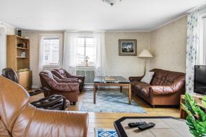 sala de estar con muebles de cuero y TV en Spacious holiday home in Flattinge, Lagan, 200 m from Lake Flaren, en Vittaryd