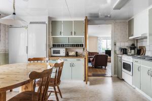 cocina y comedor con mesa de madera y sillas en Spacious holiday home in Flattinge, Lagan, 200 m from Lake Flaren, en Vittaryd