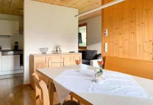 - une cuisine avec une table et deux verres de vin dans l'établissement Haus Helga, à Schoppernau