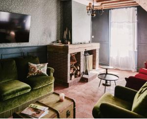 a living room with two couches and a fireplace at La Maison Pieuse in Villiers-Saint-Benoît