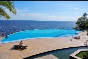 馬瑙斯的住宿－Tropical Executive Vista Maravilhosa，一个大型的游泳池,背景是大海